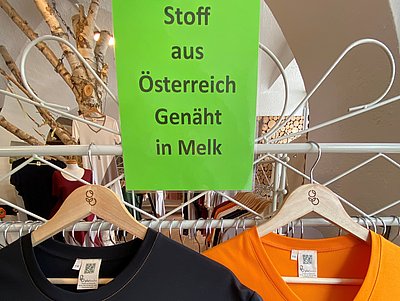 T-Shirts aus Holzfaser in dem Geschäft plufeschn, Schild: "Stoff aus Österreich Genäht in Melk"